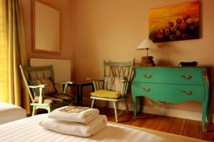 a bedroom with a bed with a dresser and two chairs at Slieve Aughty Centre in Loughrea