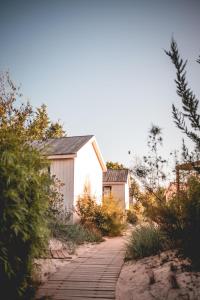 a path leading to a small white building at Le Phare in Les Portes