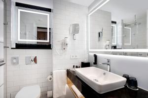 Baño blanco con lavabo y espejo en Holiday Inn - Osnabrück, an IHG Hotel en Osnabrück