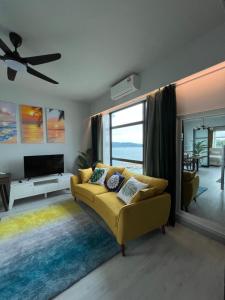 uma sala de estar com um sofá amarelo e uma grande janela em Mango House3-LuxurySweet I Biggest unit I infinity pool I Wifi-JQ em Kota Kinabalu