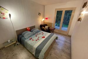 Un dormitorio con una cama con rosas rojas. en Au Calme Absolu chez Nicolas en Lindry