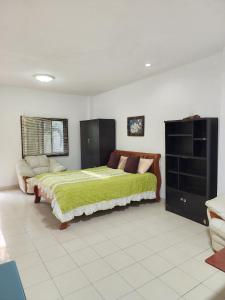 Un dormitorio con una cama grande con una manta verde. en Happy Valley Pattaya, en Jomtien Beach