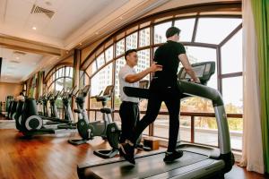 two men standing on a treadmill in a gym at InterContinental Grand Ho Tram in Ho Tram