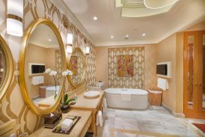 a bathroom with a tub and a large mirror at InterContinental Grand Ho Tram in Ho Tram