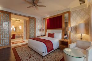 a bedroom with a large white bed and a chair at InterContinental Grand Ho Tram in Ho Tram