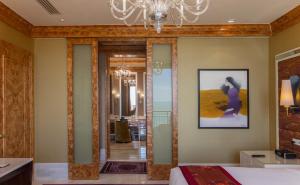 a bedroom with a large mirror and a chandelier at InterContinental Grand Ho Tram in Ho Tram