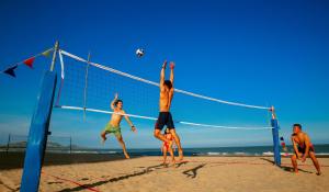 a group of people playing volleyball on the beach at InterContinental Grand Ho Tram in Ho Tram