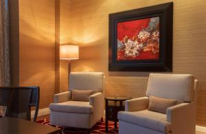 a room with two chairs and a painting on the wall at InterContinental Grand Ho Tram in Ho Tram