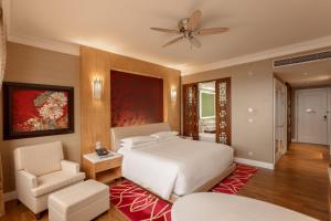 a bedroom with a white bed and a chair at InterContinental Grand Ho Tram in Ho Tram