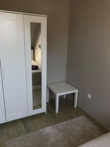 a room with a mirror and a table and a bed at Hangulatos társasházi apartman Pécs belvárosában in Pécs