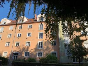 a large orange building with a lot of windows at Hangulatos társasházi apartman Pécs belvárosában in Pécs