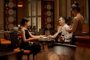a group of people sitting at a table in a restaurant at InterContinental Grand Ho Tram in Ho Tram