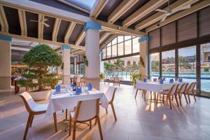a restaurant with white tables and chairs and a pool at InterContinental Grand Ho Tram in Ho Tram