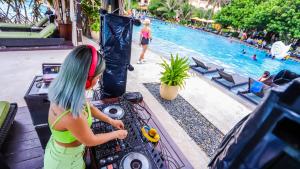 a young girl playing with a dj next to a pool at InterContinental Grand Ho Tram in Ho Tram