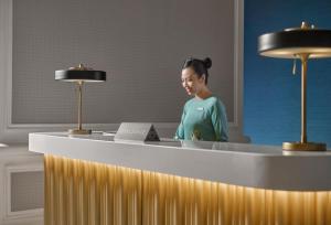 a woman standing at a desk with a laptop at InterContinental Grand Ho Tram in Ho Tram