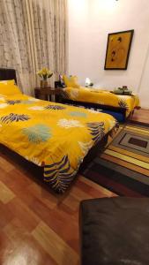 a bedroom with two beds with yellow comforters at ISLAMIC HOMESTAY @ KUALA ROMPIN , PAHANG . in Kuala Rompin