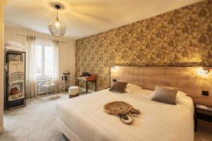 una camera da letto con un grande letto con un piatto sopra di Hôtel du Musée a Granville
