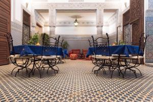 a table and chairs in a room with a tile floor at Riad Youssef in Fès
