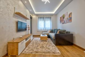 a living room with a couch and a tv at Mount Inn Gold in Zlatibor