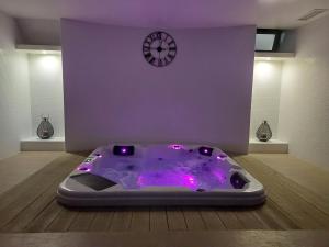 a purple tub in a room with a clock on a wall at Hotel Monte Lírio in Espinho