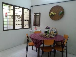 una sala da pranzo con tavolo, sedie e lavandino di Heawood Homestay Sungai Siput a Sungai Siput