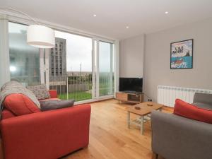 un soggiorno con mobili rossi e una grande finestra di 24 Heron Court a Bridport
