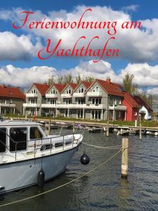 a boat docked in the water in front of houses at Apartment am Yachthafen Whg 8 optional Bootsplatz in Plau am See
