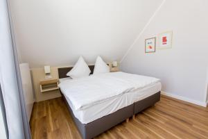 a small bedroom with a bed with white sheets at Apartment am Yachthafen Whg 8 optional Bootsplatz in Plau am See