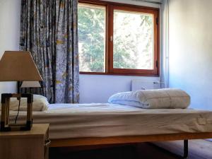 łóżko w pokoju z oknem w obiekcie Appartement 3 pièces, 8 pers, Résidence Cassiopée, Flaine Forum, à 50m des pistes et commerces - FR-1-687-87 w mieście Arâches-la-Frasse