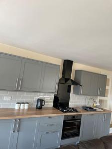 a kitchen with white cabinets and a stove top oven at Kennys apartment in Milford Haven