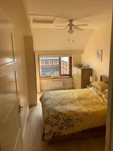 una camera con letto e ventilatore a soffitto di Kennys apartment a Milford Haven