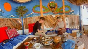 dos personas sentadas en un sofá en una tienda en Agachill Surf House, en Tamraght Ouzdar