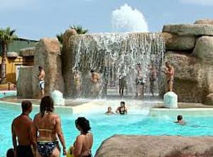 un grupo de personas en una piscina con cascada en Boutique Style Apartment in Velez de Benaudalla - near Salobrena, en Vélez de Benaudalla