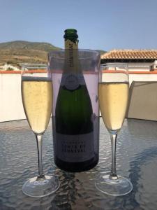 a bottle of champagne and two glasses on a table at Boutique Style Apartment in Velez de Benaudalla - near Salobrena in Vélez de Benaudalla