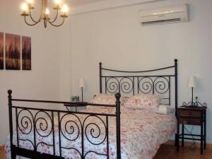 a bedroom with a black bed and a chandelier at Boutique Style Apartment in Velez de Benaudalla - near Salobrena in Vélez de Benaudalla +40 photos