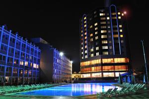 a pool in front of two tall buildings at night at Kumburgaz Marin Princess Hotel in Büyükçekmece
