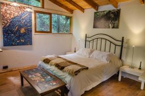 - une chambre avec un lit et une peinture murale dans l'établissement la casa del sol, à San Carlos de Bariloche