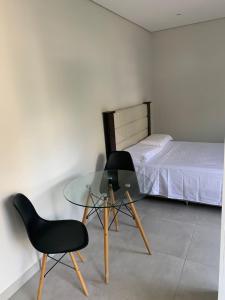 1 dormitorio con mesa de cristal y silla en Depto en Asuncion- excelente ubicación- Villa Morra #402, en Asunción