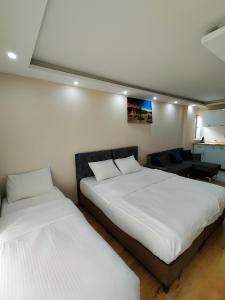 BLUE ROYAL HOTEL في إسطنبول: سريرين في غرفة ذات أغطية بيضاء