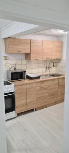 a kitchen with wooden cabinets and a sink and a stove at SG Apartment in Freistadt