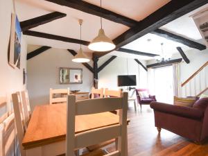 a dining room and living room with a table and chairs at Holly Cottage in Beaworthy