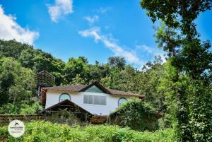 a white house in the middle of a forest at mangosteen holidays in Vythiri