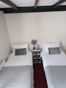 two beds sitting next to each other in a room at George Inn st briavels in Lydney