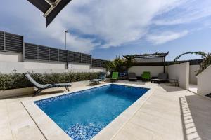 a swimming pool in the middle of a patio at Villa Azzuro with jacuzzi and pool in Sveti Filip i Jakov