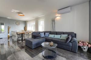a living room with a couch and a table at Villa Azzuro with jacuzzi and pool in Sveti Filip i Jakov