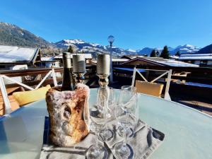 a table with two bottles and glasses on it at KITZ DREAM im Zentrum mit Sauna by Belle Stay in Kitzbühel