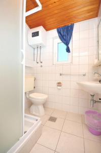 La salle de bains est pourvue de toilettes et d'un lavabo. dans l'établissement Apartments and Rooms On the Beach, à Vodice