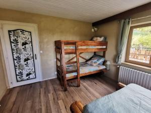 a bedroom with two bunk beds and a window at L'Estive, gîte à la ferme en montagne in Eschbach-au-Val