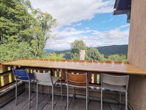 a table and chairs on a balcony with a view at L'Estive, gîte à la ferme en montagne in Eschbach-au-Val