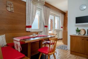 a dining room with a table and chairs and a television at A. Paolo Apartments in Vigo di Fassa